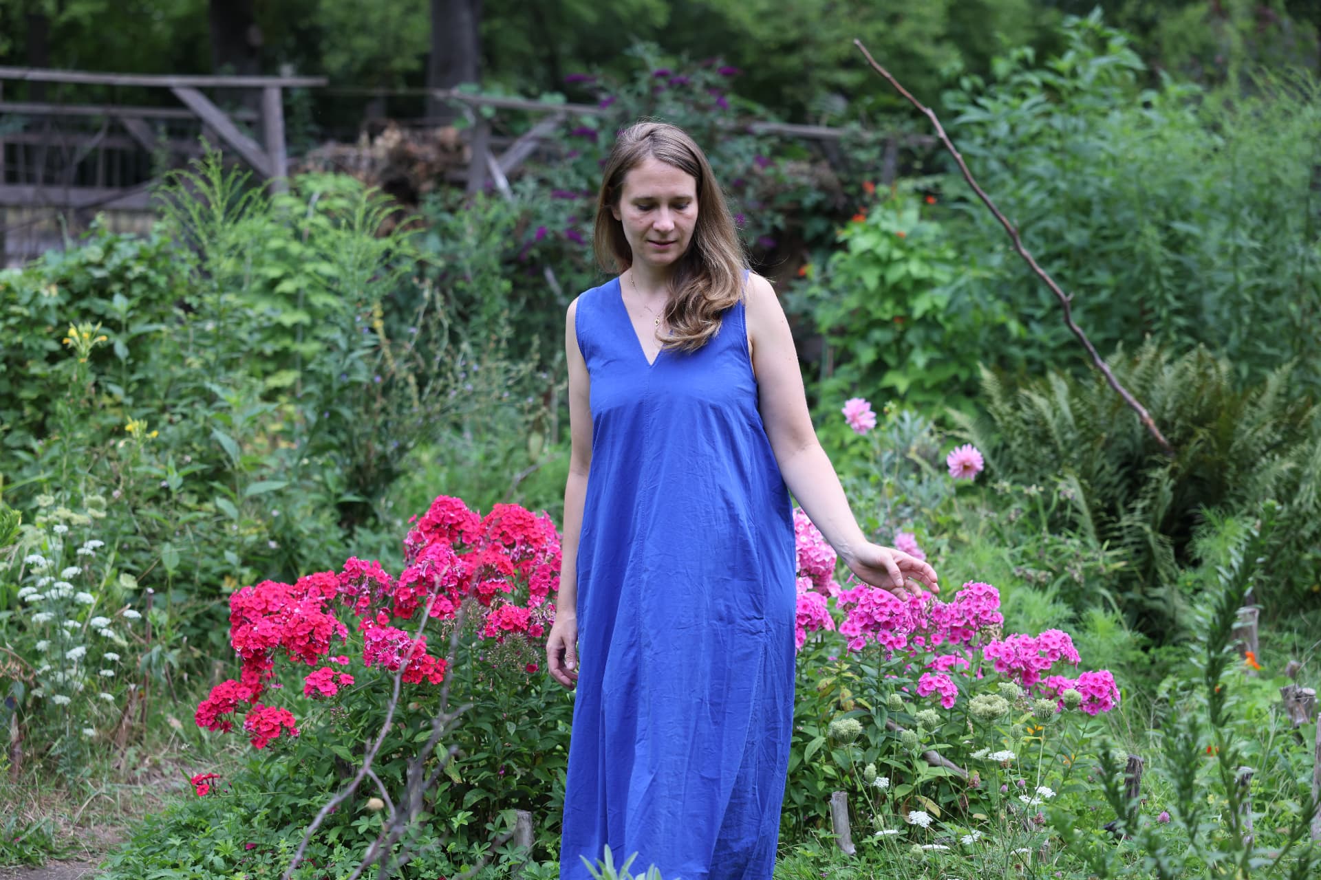 Marie in a garden of pink flowers in a prayer pose